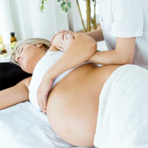 A lady holding her baby after receiving postnatal reflexology treatment